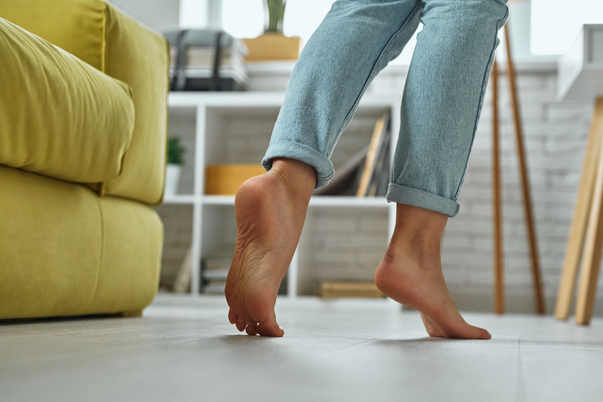close-up-of-barefoot-woman-walking-on-wooden-floor-at-home
